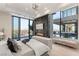 A luxurious main bedroom with floor-to-ceiling windows showcasing panoramic city views and a cozy fireplace at 1491 Reims Dr, Henderson, NV 89012