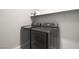 This modern laundry room has a large washer and dryer beneath a storage shelf for organization at 15 Santo Mio Ct, Henderson, NV 89011