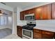 Updated kitchen with wooden cabinets, stainless steel microwave, and stainless steel gas oven at 1550 Jamielinn Ln # 102, Las Vegas, NV 89110