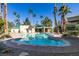 Beautiful community pool featuring clear blue water, a sun deck, and lush landscaping with many palm trees at 1550 Jamielinn Ln # 102, Las Vegas, NV 89110