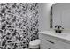 Stylish bathroom featuring modern fixtures, black hardware, and bold wallpaper at 189 Regal Sunset Ave, Henderson, NV 89002