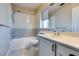 Bright bathroom featuring tiled walls, a tub and shower combo, and a vanity with sink at 189 Regal Sunset Ave, Henderson, NV 89002