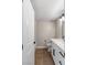Well-lit bathroom featuring a white vanity with black hardware and wood-look floors at 1943 Hallwood Dr, Las Vegas, NV 89119