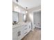 Bathroom features a double sink vanity with modern fixtures, neutral paint, and wood-look floors at 1943 Hallwood Dr, Las Vegas, NV 89119