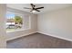 Carpeted bedroom with a ceiling fan and a view of the neighborhood through a window at 1943 Hallwood Dr, Las Vegas, NV 89119