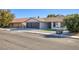 Street view of home with large driveway, three car garage, and low maintenance landscaping at 1943 Hallwood Dr, Las Vegas, NV 89119