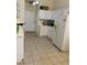 Bright kitchen featuring white cabinets, appliances, tile floors, and a door to the outside at 2050 N Los Feliz St # 114, Las Vegas, NV 89156