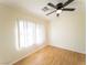 Bright bedroom featuring light walls, hardwood floors, and a ceiling fan with light fixture at 211 Kansas Ave, Henderson, NV 89015