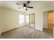 Bedroom featuring neutral walls, carpet flooring, mirrored closet, adjacent bathroom and ceiling fan at 211 Kansas Ave, Henderson, NV 89015