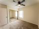 Bedroom featuring neutral walls, carpet flooring, ceiling fan and mirrored closet at 211 Kansas Ave, Henderson, NV 89015