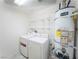 Bright laundry area with washer, dryer, shelves, and water heater in a well-lit space at 211 Kansas Ave, Henderson, NV 89015