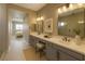 Well-lit main bathroom with dual sinks, neutral color tones, and vanity seating at 2194 Pigeon Hawk St, Las Vegas, NV 89138