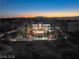 Luxury twilight view of a large home, pool, immaculate landscaping, and a backdrop of mountains at 22 Anthem Pointe Ct, Henderson, NV 89052