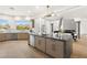 An open-concept kitchen and living space with a large island, stylish lighting, and modern appliances at 22 Anthem Pointe Ct, Henderson, NV 89052