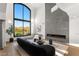 A modern living room features a soaring window, elegant fireplace, and stylish furniture, perfect for relaxation and entertaining at 22 Anthem Pointe Ct, Henderson, NV 89052