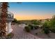 Elegant patio with lush garden views, outdoor seating, a built-in fire pit, and manicured landscaping at 22 Anthem Pointe Ct, Henderson, NV 89052
