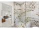 Modern bathroom features a luxurious glass shower with elegant marble tiling and gold fixtures at 22 Anthem Pointe Ct, Henderson, NV 89052