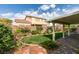 Serene backyard featuring a covered patio, manicured lawn, and landscaped garden, perfect for relaxation and entertaining at 2418 Brockton Way, Henderson, NV 89074