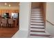 Bright, inviting staircase featuring natural wood steps and a white painted frame, adjacent to an open kitchen space at 2418 Brockton Way, Henderson, NV 89074