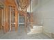 Unfinished basement featuring an exposed staircase, pipes, electrical and the garage door for a complete renovation at 2471 Old Forge Ln # 103, Las Vegas, NV 89121