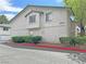 Well-maintained two-story condo with neutral stucco exterior, green roof accents and a landscaped yard at 2471 Old Forge Ln # 103, Las Vegas, NV 89121
