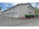 Exterior features assigned garage parking, well maintained stucco, and neat landscaping at 2471 Old Forge Ln # 103, Las Vegas, NV 89121