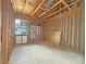 Interior view of a framed room features a window overlooking a neighboring property and a plywood subfloor at 2471 Old Forge Ln # 103, Las Vegas, NV 89121