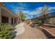 Desert landscaped backyard featuring a retaining wall and a covered patio at 3004 Canton Hills St, Henderson, NV 89052