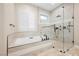 Elegant bathroom featuring a freestanding tub and a glass-enclosed shower with modern fixtures and tiled accents at 3004 Canton Hills St, Henderson, NV 89052