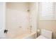 Bathroom with a shower-tub combo and bright natural light from window with shutters at 3004 Canton Hills St, Henderson, NV 89052