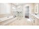 Luxurious bathroom featuring a soaking tub, a glass shower, and double vanities with stone countertops at 3004 Canton Hills St, Henderson, NV 89052