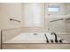 Contemporary bathroom featuring a soaking tub, with modern fixtures and natural light from plantation shutters at 3004 Canton Hills St, Henderson, NV 89052
