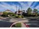 Beautifully landscaped roundabout with American flags and clubhouse in the background at 3004 Canton Hills St, Henderson, NV 89052