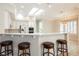Kitchen with bar seating, skylight, and white cabinetry at 3004 Canton Hills St, Henderson, NV 89052