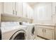 Bright laundry room featuring white cabinets, modern appliances, and a convenient sink area, offering functionality and style at 3004 Canton Hills St, Henderson, NV 89052