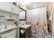 Simple bathroom features a tub/shower combo, wood cabinet and white shelving at 304 S Crestline Dr, Las Vegas, NV 89107