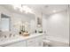 Bright bathroom featuring double sinks, modern fixtures, and a bathtub shower at 3915 Wesvan Ct, Las Vegas, NV 89121