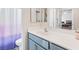 Bright bathroom featuring a white sink, blue vanity, toilet, and bathtub with shower curtain at 4014 Sparrow Rock St, Las Vegas, NV 89129