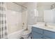 Bright bathroom features a shower-tub combination and a blue vanity with a white countertop at 4014 Sparrow Rock St, Las Vegas, NV 89129