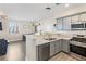 Bright kitchen with stainless steel appliances, sleek gray cabinets, and an adjacent dining area at 4014 Sparrow Rock St, Las Vegas, NV 89129