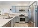 Well-lit kitchen with stainless steel appliances, gray cabinets, quartz countertops, and modern fixtures at 4014 Sparrow Rock St, Las Vegas, NV 89129