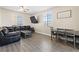 Cozy living room featuring wood-look floors, a comfortable black sofa, and a dining set at 4014 Sparrow Rock St, Las Vegas, NV 89129