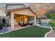 Outdoor view of backyard with pool, turf, seating, patio, and outdoor lighting at 4573 Milvio Ave, Las Vegas, NV 89141