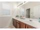 Bright bathroom with double sinks, brown cabinets and white shutters at 4573 Milvio Ave, Las Vegas, NV 89141