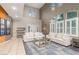 Bright and airy living room boasts soaring ceilings, large windows, and a comfortable seating area at 4573 Milvio Ave, Las Vegas, NV 89141