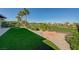 Backyard featuring artificial grass, a putting green, and mature palm trees at 4574 Fiore Bella Blvd, Las Vegas, NV 89135