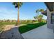 Landscaped backyard featuring artificial grass putting green and views of the golf course at 4574 Fiore Bella Blvd, Las Vegas, NV 89135