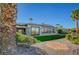 Backyard featuring artificial grass, desert landscaping, and covered patio at 4574 Fiore Bella Blvd, Las Vegas, NV 89135