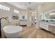 Spacious bathroom with a freestanding tub, double vanities, and plenty of natural light at 4574 Fiore Bella Blvd, Las Vegas, NV 89135