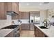 Well-equipped kitchen featuring stainless appliances, wood cabinets, and marble countertops at 4574 Fiore Bella Blvd, Las Vegas, NV 89135